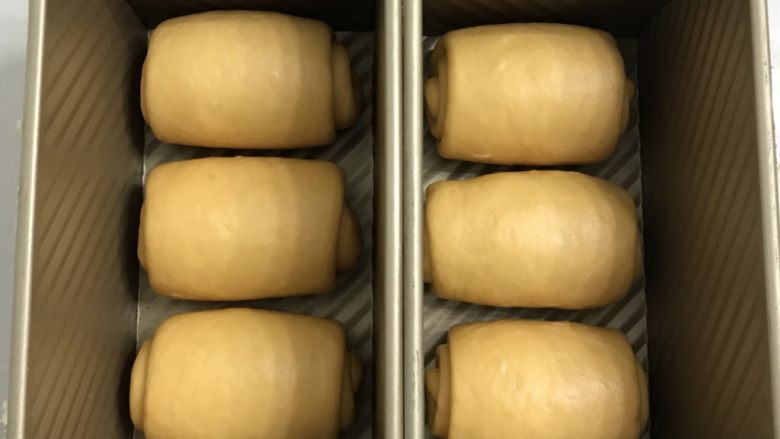南瓜烫种炼乳吐司,18顺一个方向放入吐司盒,周围要留有余地。