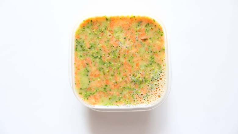 西兰花胡萝卜鸡蛋蒸糕(适合12个月龄以上的宝宝),容器里面涂抹适量的宝宝食用油,倒入蔬菜蛋糊