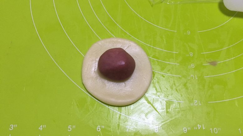 桃花酥,取一个水油皮按扁,擀圆,包入一个油酥