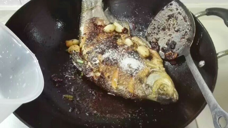 厨房挑战+荤菜+大蒜头黄豆酱烧鳊鱼,放和鳊鱼平齐的热水,盖上锅盖烧开翻个面再烧十分钟