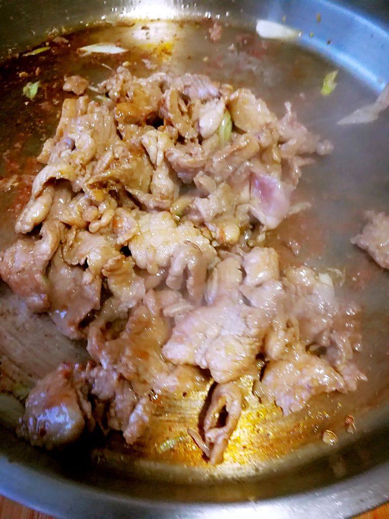 烤里脊肉夹火烧,烙好饼再把腌好的肉放入电饼铛或平底锅,煎炒,不断的翻拌。