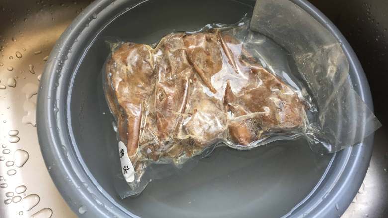 干锅土豆鸭头,将鸭头隔着包装袋冷水解冻;