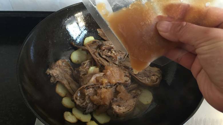 干锅土豆鸭头,倒入干锅香酱一起煮;