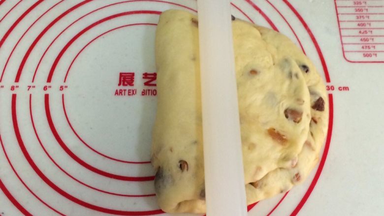 圣诞面包史多伦,把擀平部分折叠到上方,用擀面杖压下。