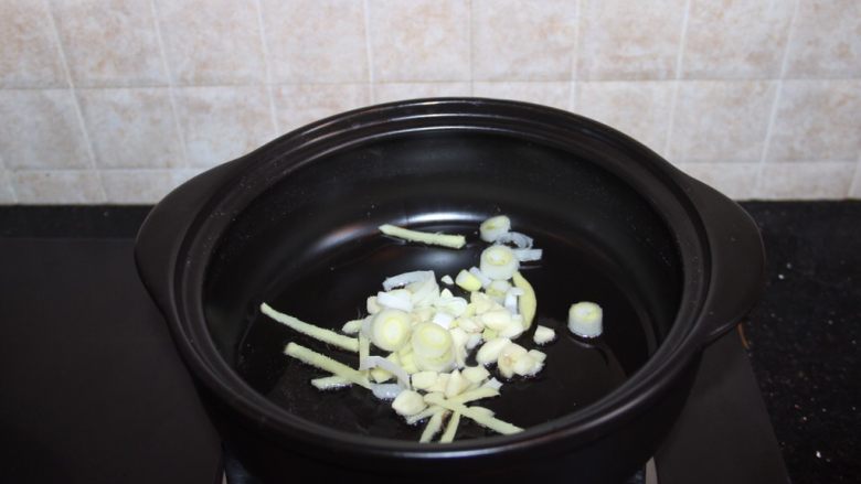 砂锅爆炒鱿鱼,砂锅内放油,放入葱姜蒜爆香