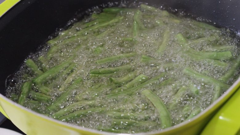 干煸豆角,素菜中的挖掘机,目的是炸出豆角中部分水份,这是中火煎炸一分钟后的样子,明显比刚下锅软了。
