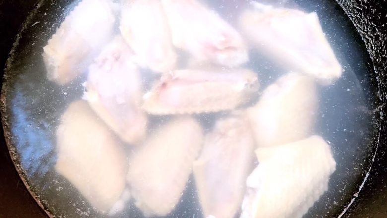 可乐炖鸡翅,锅中烧开水将鸡翅焯水至鸡翅变色后放入冷水中过凉
