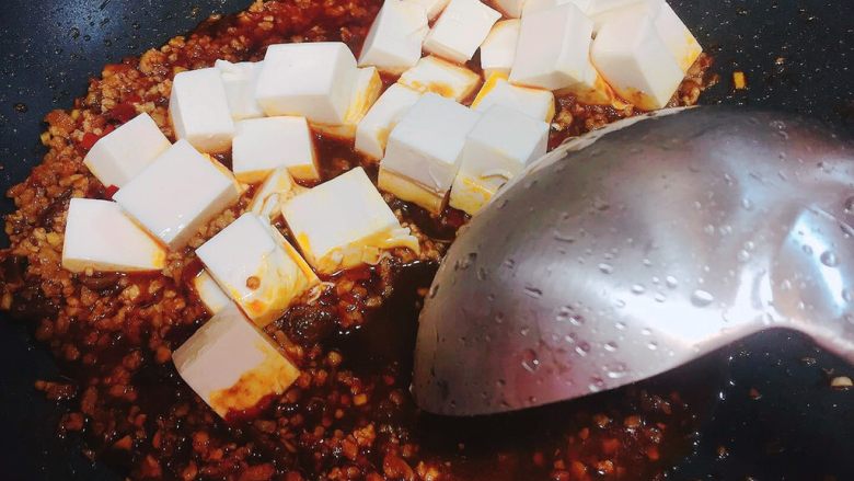 麻婆豆腐,用炒勺光滑的一面沿着锅边推散豆腐,这样豆腐不容易碎