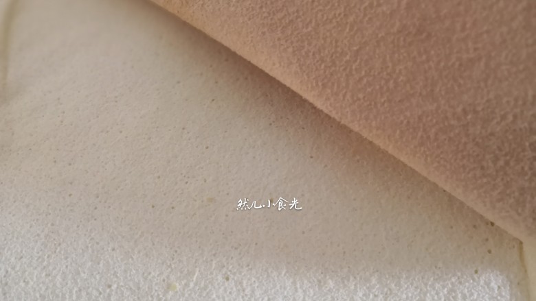 芒果蛋糕卷,预热烤箱170度,将烤盘放入烤箱中层,烤18—20分钟左右(具体烤制时间和温度根据自己烤箱脾气做调整)出炉后震一下烤盘,在凉架上铺上油纸,将蛋糕迅速从烤盘里移出倒扣在油纸上,揭去低层油布,在盖上一层油纸防止蛋糕变干。