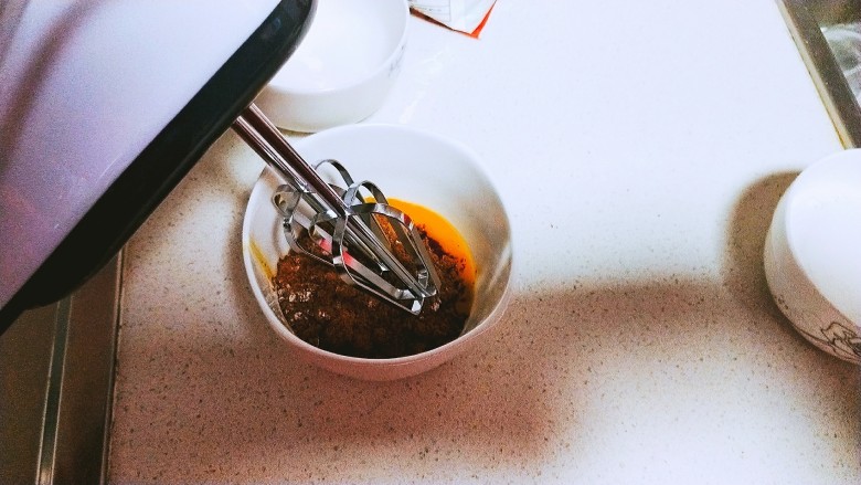 红糖蛋黄纸杯蛋糕,将红糖加入蛋黄中,用电动打蛋器打发蛋黄,打至全发,呈浓稠发白状态。