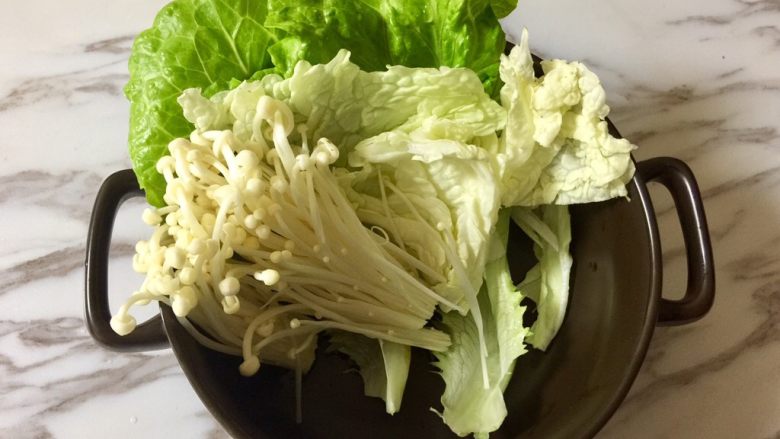 快手暖胃番茄火锅,在砂锅里,一层一层码上蔬菜和金针菇。