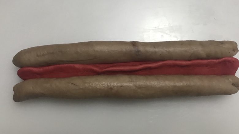圣诞帽吐司,然后红色面团尖的在上面,可可色面团尖的往下和红色面团并起来。注意红色在中间。