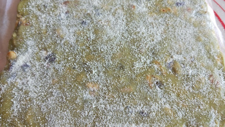 抹茶雪花酥,放凉后取出放硅胶垫上,两面都撒上一层薄薄的的奶粉