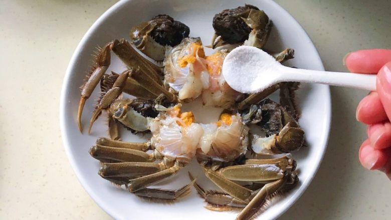 金腿醉螃蟹,放入盘内,撒少许的盐在蟹肉上