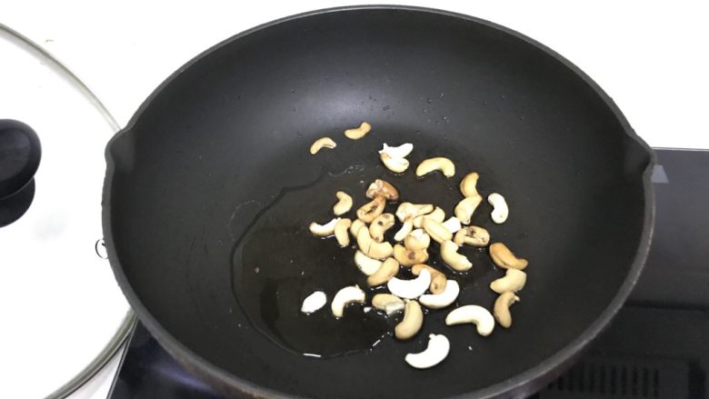 牛肉芹菜炒腰果,腰果倒入锅中,放比较多的油不停翻炒,类似于炒花生一样,可以让腰果保持脆感,炒好后装碗盛出放凉。