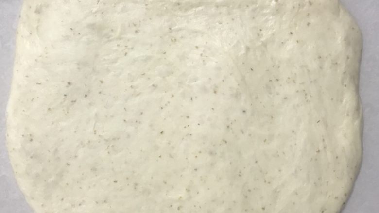 烫种全麦吐司,把分割下来的小面团压在底下,用擀面杖擀开,整理成小长方型。