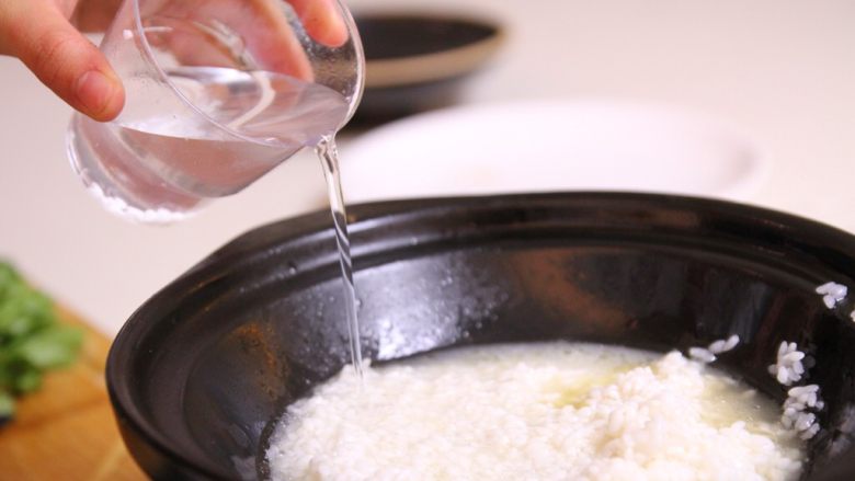 腊味煲仔饭,3、加入1:1.5的水,倒入锅中,盖上盖子焖煮到边缘冒泡,水开就可以。