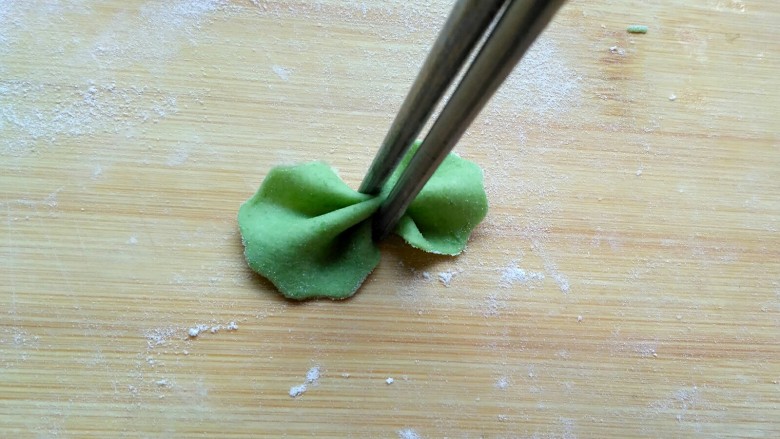 菠菜蝴蝶面,用筷子在中间夹一下,不要太使劲会夹断。剩下的边边角角在揉成面团擀成薄饼,重复上述步骤,做成蝴蝶面……