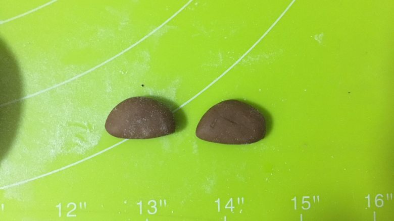 呆萌熊猫豆沙包,取一个可可小面团,按压成圆形,中间切开,作为耳朵