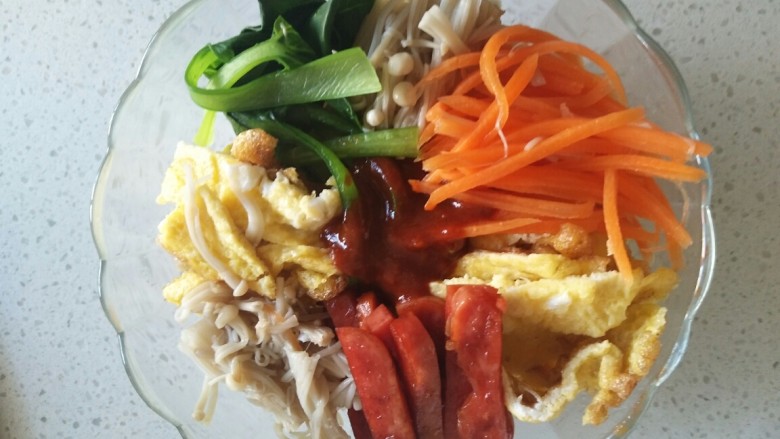 韩式蔬菜拌饭,在碗里放入蒸好的米饭,依次将蔬菜摆在米饭上,把调好的辣酱浇在米饭中间,漂亮的韩式蔬菜拌饭就做好了。