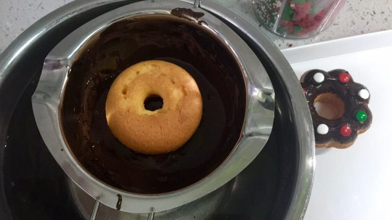 甜美可爱的圣诞甜甜圈,把纯圆的甜甜圈的正面朝下,蘸上巧克力酱。