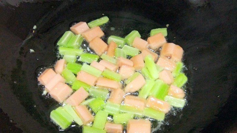 菠萝炒饭,锅内放油适量,倒入莴笋和火腿肠翻炒