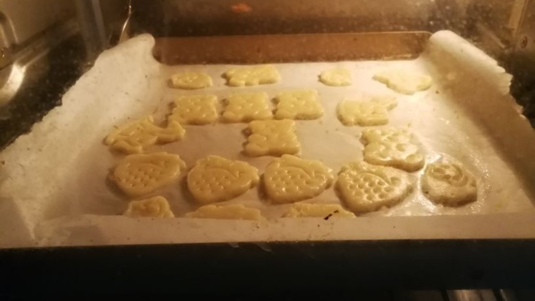 童趣动物饼干,印制饼干坯时就可以200度预热烤箱,印好的饼干坯连同油纸一起移至烤盘上,放入烤箱中层烘烤,上下火180度15分钟