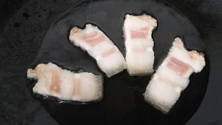 回锅肉,锅内放油烧热,将肉放进锅内煎