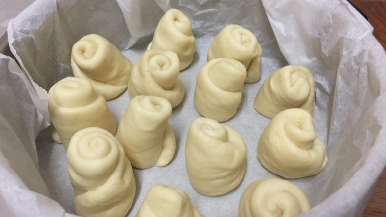 淡奶油餐包,然后从中间一分为二,将切面朝下,放入铺有硅油纸的磨具中,盖上保鲜膜继续发酵至2倍大