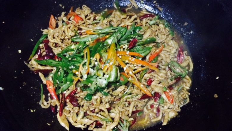 乡味香辣肉丝,接着加入青辣椒,翻炒均匀
