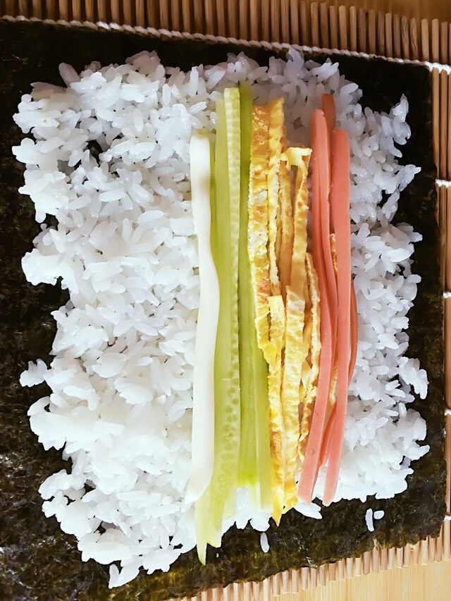 寿司
,
然后就是铺菜菜了,之所以把食材都切条状就是为了此时好铺。铺上自己喜欢的菜菜后可以洒点肉松或者沙拉酱之类的。(喜欢辣的同学可以在铺之前在米饭上先抹一层辣椒酱,我老公就比较喜欢辣的呵呵) 铺完之后从没有留白的那一头紧紧的卷起即