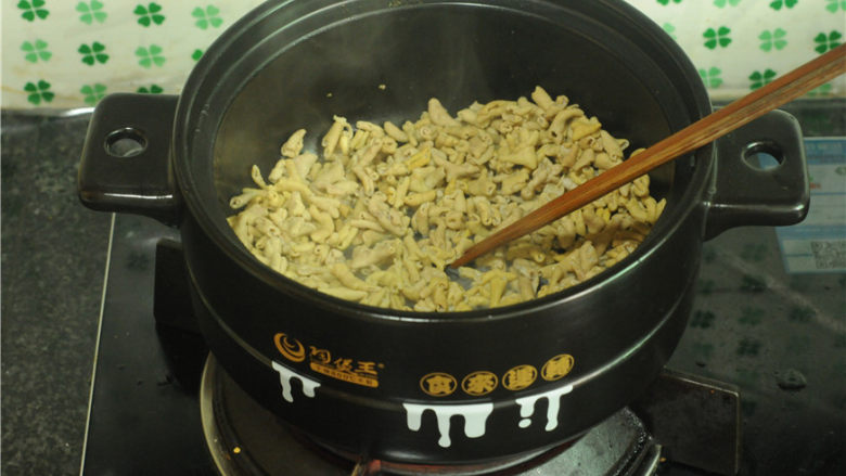 干锅鸭肠,用筷子不停搅拌,将水分炒干