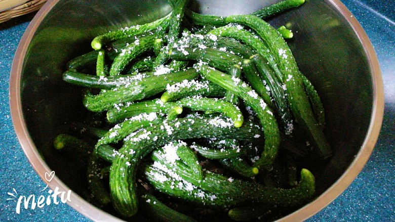 油焖小黄瓜咸菜,晾干后的黄瓜撒上食盐拌匀,使每根黄瓜上都沾上食盐,腌制一晚。如果你是用切好的黄瓜条,就不用腌一晚上,只腌3—4个小时就差不多了。