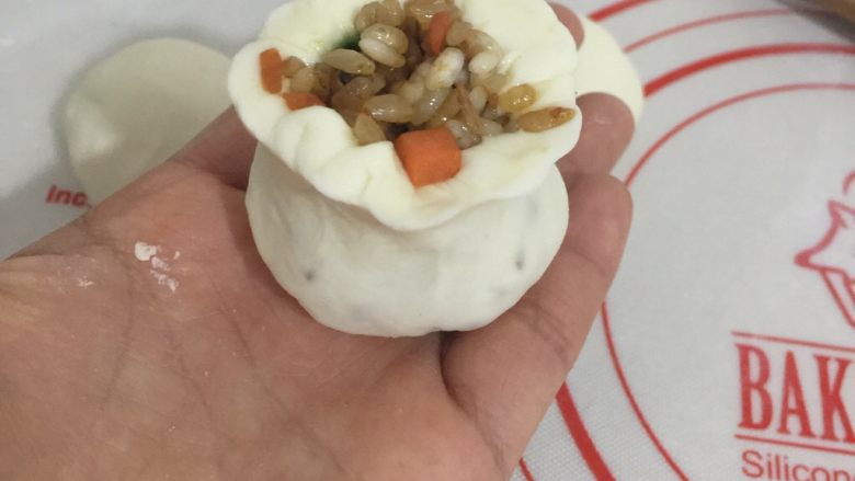 糯米烧卖,这是包好的样子,我的包法是:面皮放入馅料后用右手的虎口包住面皮,左手将馅料压着,右手开始旋转,边旋转边捏紧形成这样的收口就可以了,依次全部做完