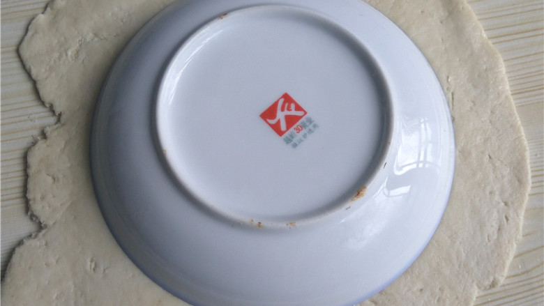 玉米煎饼,将面团擀成均匀厚薄的面片;饭碗倒扣,压出圆形面片;