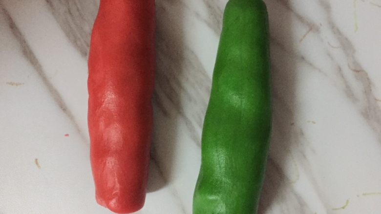圣诞树饼干,将两个面团搓成圆柱形。并列,抓几下。在揉成一个圆柱。