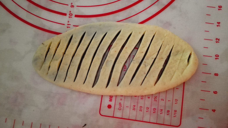 黑芝麻面包圈,用刀在中间均匀地切出条纹,四周不要切开,