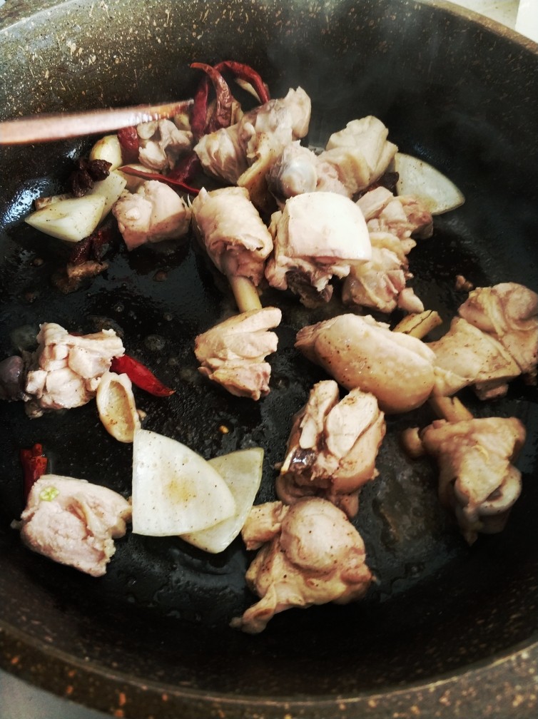 大盘鸡拉条子,热锅凉油,下干辣椒,八角,五香粉,一部分洋葱,炒一下放入鸡块,