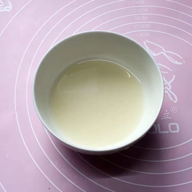寿桃馒头,先将酵母粉加入适量温水搅匀融化,静置一会。