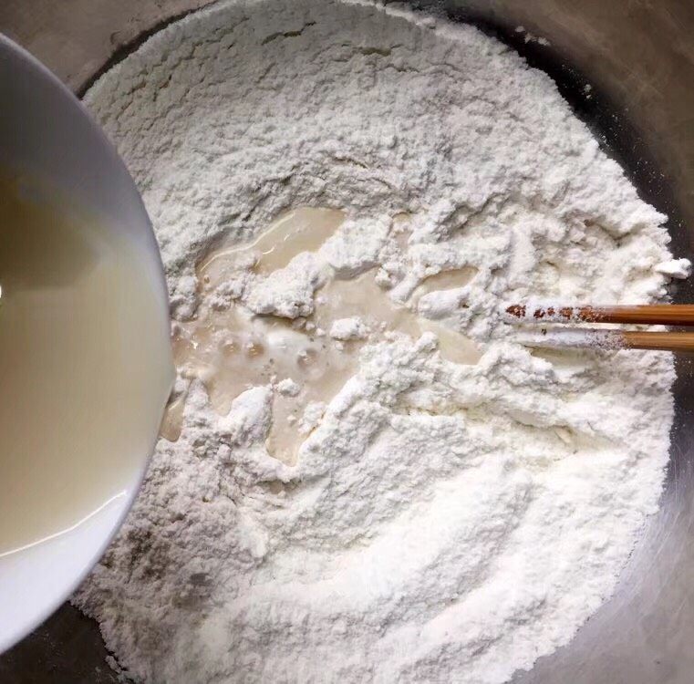 寿桃馒头,加入酵母水,边加边用筷子搅拌成絮状。