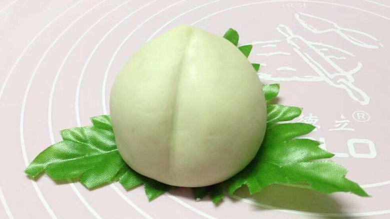 寿桃馒头,将捏好的桃子放在绿叶上,这样是不是更像了。(可以自己做菠菜汁绿叶)
