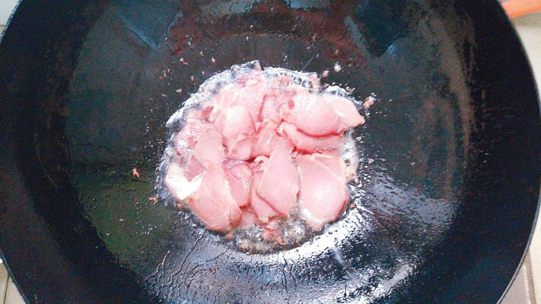 双椒茭头炒腊肉,腊肉片倒入热油锅里煸炒出香味!
