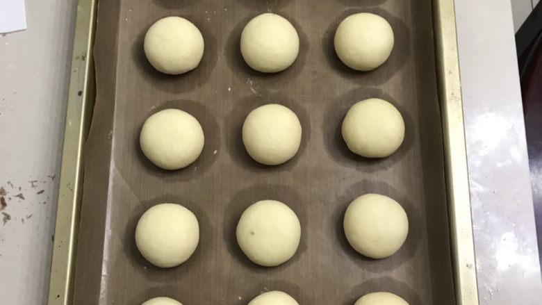 奶香豆沙小餐包,用二手掌搓圆,放入烤盘