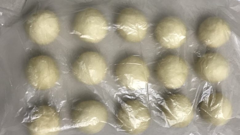 奶香豆沙小餐包,滚圆盖上保鲜膜,室温松弛20分钟