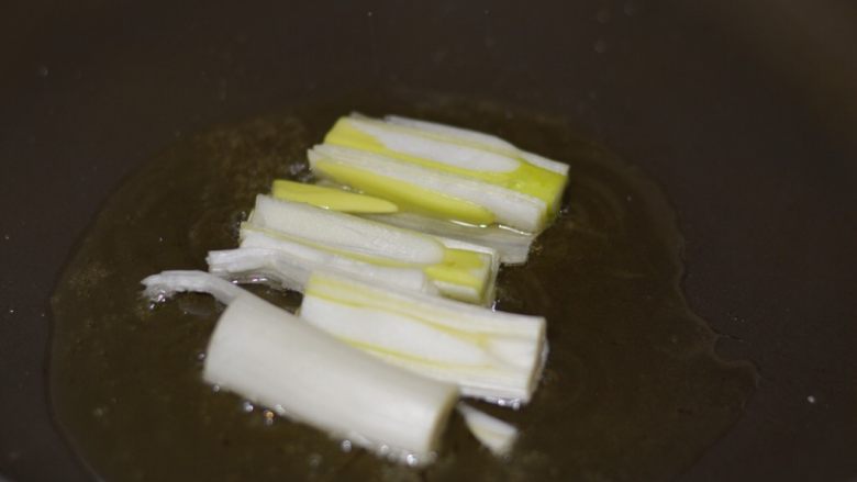 葱烧红极参,葱切成段,锅里放入适量油,有热后放入葱段爆香至微微焦黄,然后捞出葱段放入盘中。