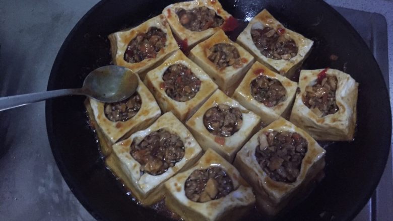 橙香肉末酿豆腐,煎至汤汁浓稠,用勺子把汤汁浇到豆腐和肉上