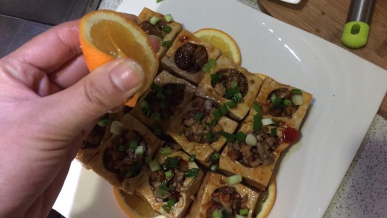 橙香肉末酿豆腐,摆橙子上,撒上葱花,挤上橙汁
