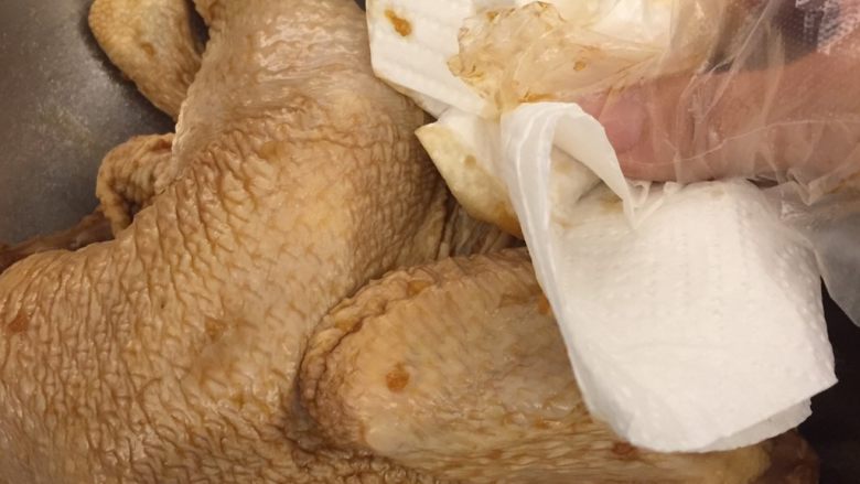 中国式圣诞节上的烤鸡,两天过去了,把腌好的鸡取出,用厨房纸巾尽量抹掉蒜末。