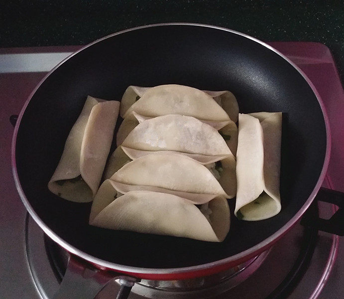 磷虾肉韭菜锅贴,平底锅烧热倒入菜籽油、均匀摆上包好的生磷虾锅贴