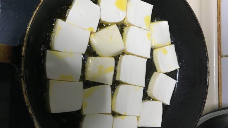 猫厨物语—自创干锅闷烧肉末豆腐,热锅倒油。油6、7成热的时候,把豆腐一块一块摆进锅里,小火慢煎。